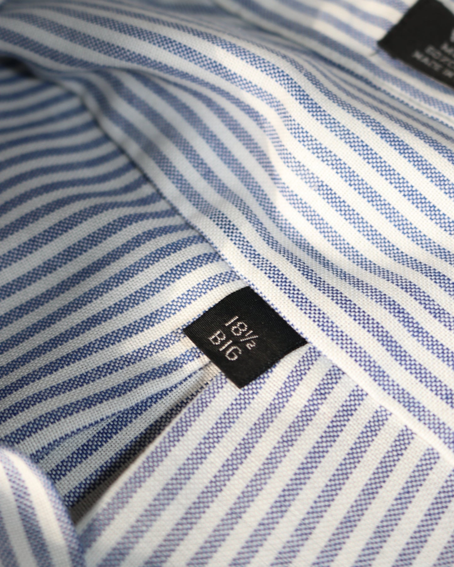 Close-up of a blue and white striped shirt with a size label.