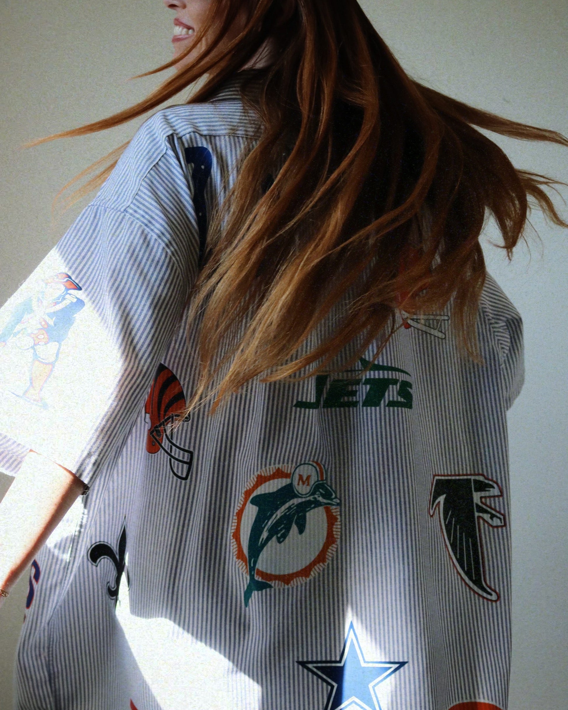 Person wearing a shirt with various sports team logos
