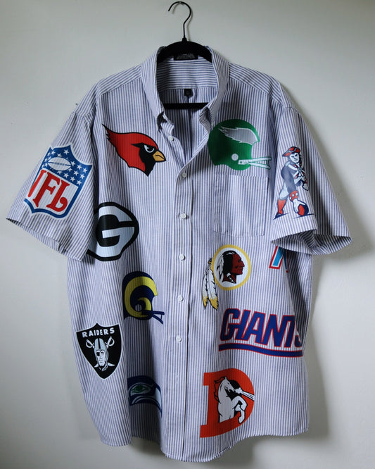 Shirt with sports team logos on a hanger against a plain background