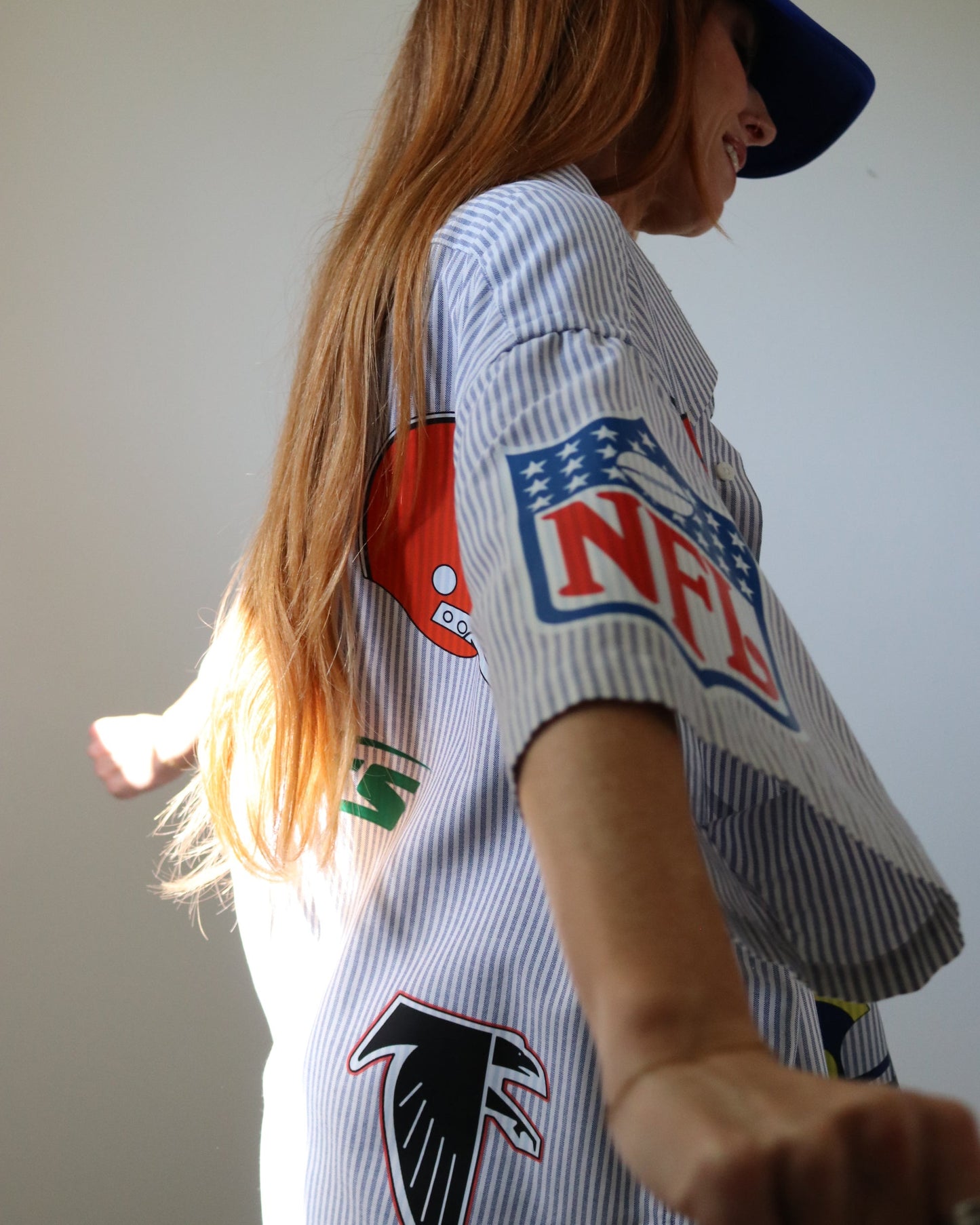 Person wearing a sports jersey with NFL logo on a plain background