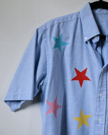 Blue shirt with colorful stars on a plain background
