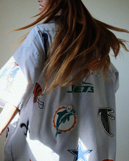 Person wearing a shirt with various sports team logos