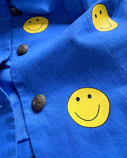 Blue fabric with yellow smiley face patterns and metal buttons