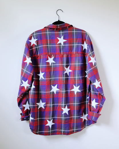 Plaid shirt with star pattern on a hanger against a white background