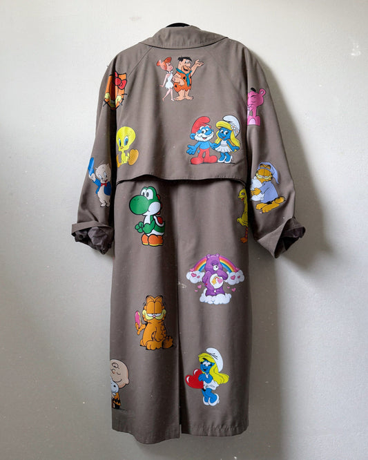 A trench coat with a colorful cartoon character pattern displayed on the back half, in shades of gray, green, and other colors.